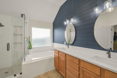 Luxurious primary bath with dual vanities, soaking tub, walk in shower and designer accent wall.