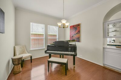 Elegant formal dining space with rich wood flooring and abundant natural light.