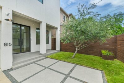 Elegant front porch with landscaped yard and modern exterior finishes.